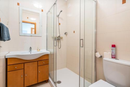 Un baño con ducha, lavabo e inodoro. en Apt Brightness Comfort In Burgau, en Burgau