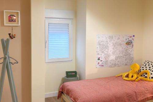 a bedroom with a bed with a yellow stuffed animal on it at Parkside Retreats at 1880 House in Bermeo