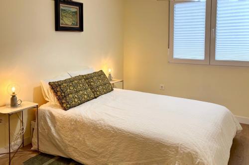 a bedroom with a white bed with a pillow on it at Parkside Retreats at 1880 House in Bermeo
