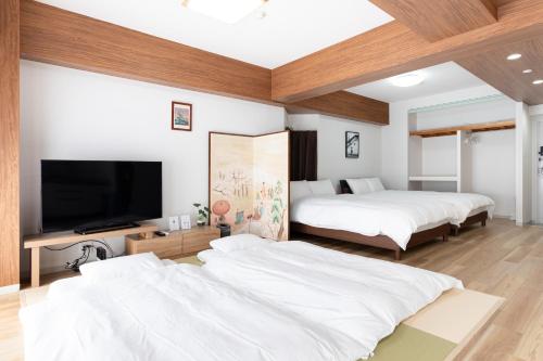 Un dormitorio con dos camas y un televisor de pantalla plana. en エクセレンス大阪城公園 - Osaka Castle Excellence, en Osaka
