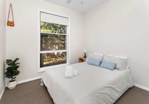 a bedroom with a large white bed with a window at Serendib School holiday special only 375 per night in Gerringong