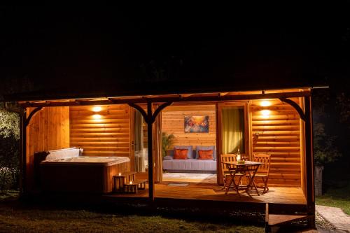 a small cabin with a hot tub and a table at Réteskert vendégház és apartman in Bélapátfalva