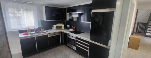 a small kitchen with black cabinets and a microwave at Villa- SARA in Lavamünd