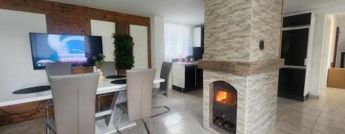 a living room with a fireplace and a desk and a tv at Villa- SARA in Lavamünd