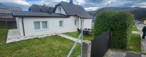 a white house with a fence in front of it at Villa- SARA in Lavamünd