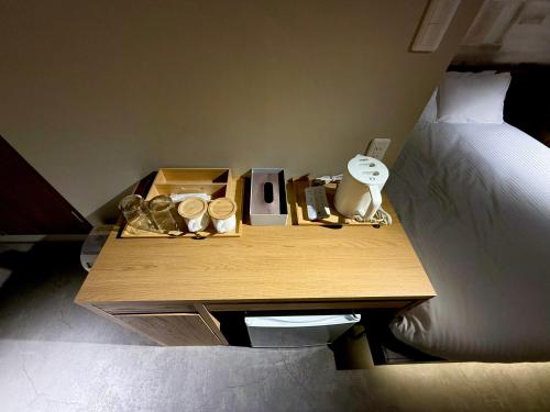 a bed room with a wooden table with a bed and a bedskirts at Hotel KOTO in Sapporo