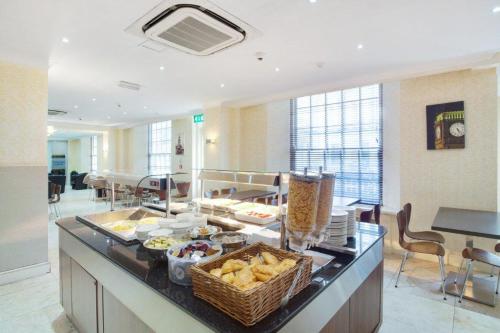a buffet in a hotel room with food on a counter at Queens Park Hotel in London