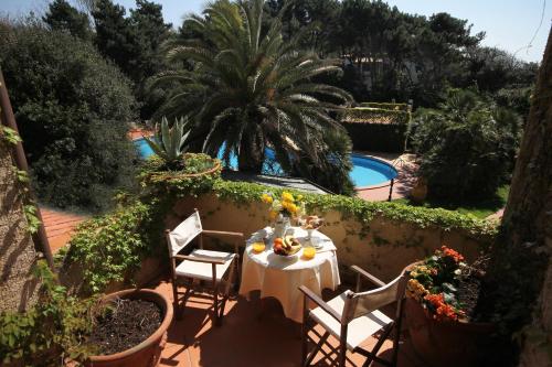 a table and chairs on a patio next to a pool at Hotel Villa Maremonti in Marina di Massa