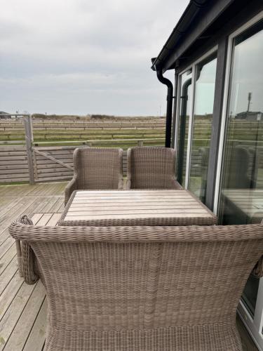 a wicker table and chairs sitting on a porch at Apelvy Panorama in Varberg