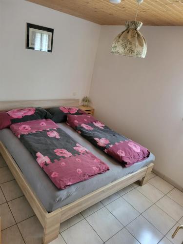 - un lit dans une chambre avec des draps roses dans l'établissement Monis ruhiges Ferienhaus, à Ménétreuil