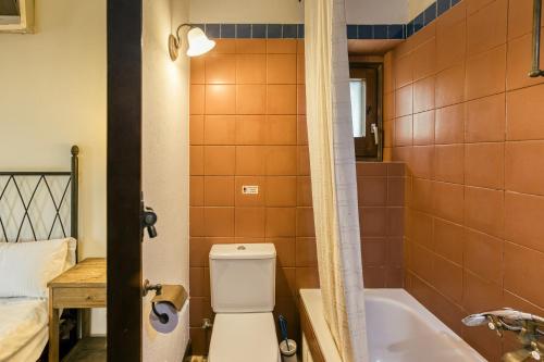 a bathroom with a toilet and a bath tub at Habitacions Mas Fuselles in Girona