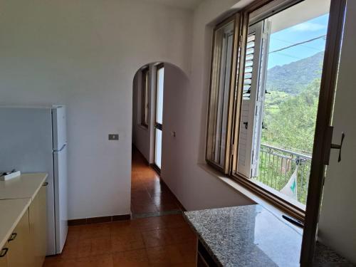 a kitchen with a large window with a view at Casa relax Berchida in Capo Comino
