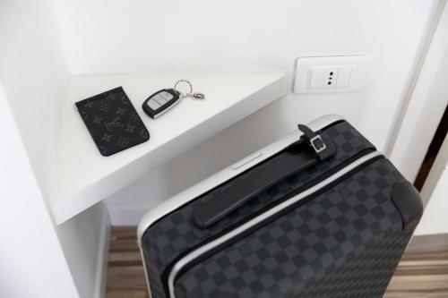 a suitcase sitting on top of a white shelf at Hi Hotels Torbole - Heated Outdoor Pool & Spa in Nago-Torbole