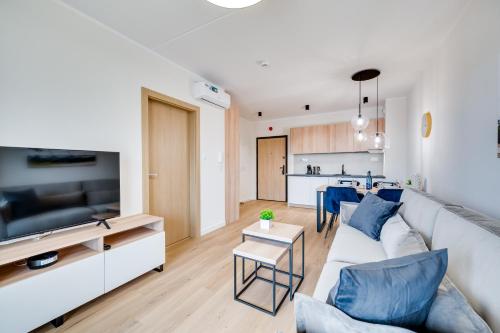 a living room with a white couch and a kitchen at ReVital Mechelinki by Homeprime Parking Free in Mechelinki