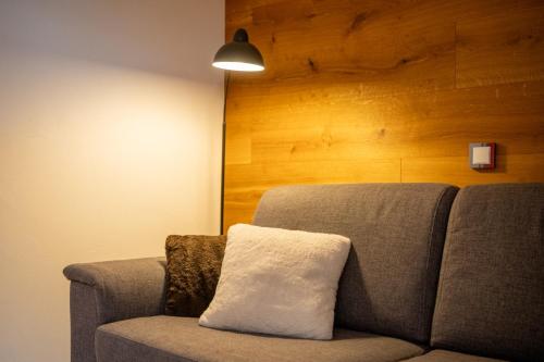 a couch with a white pillow on top of it at Ferienhaus Gäbi - Ferienwohnungen in Wiler