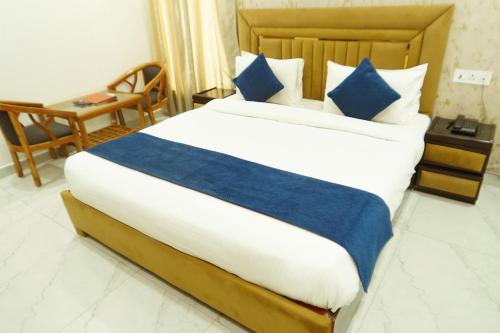 a bedroom with a large bed with blue pillows at MK Regency in Greater Noida