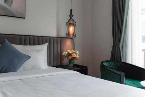 a bedroom with a bed and a vase of flowers on a table at 22 Land Hotel in Hanoi