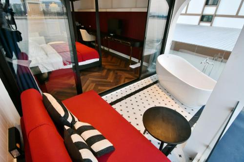 a small room with a red couch and a toilet at เลอค่าเชียงแสน Le Quar Cafe BistroBed & Breakfast in Golden Triangle