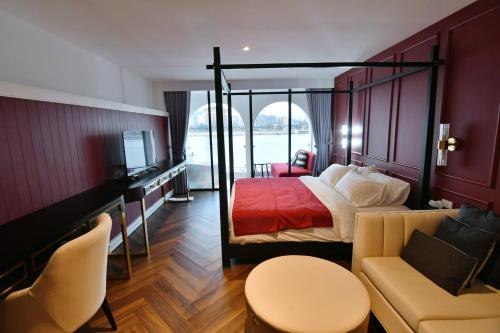 a hotel room with a bed and a couch at เลอค่าเชียงแสน Le Quar Cafe BistroBed & Breakfast in Golden Triangle