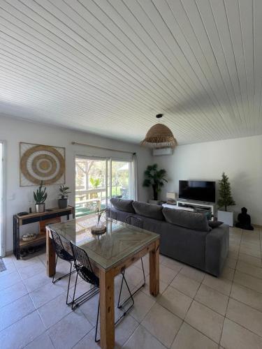 un salon avec un canapé et une table dans l'établissement Agréable maison de vacances, à Soustons