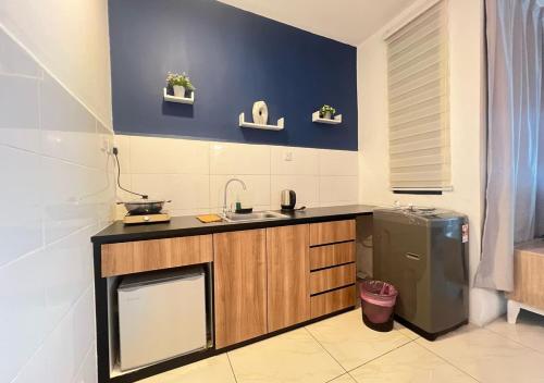 a kitchen with a sink and a refrigerator at ITCC Manhattan by IGVC in Penampang