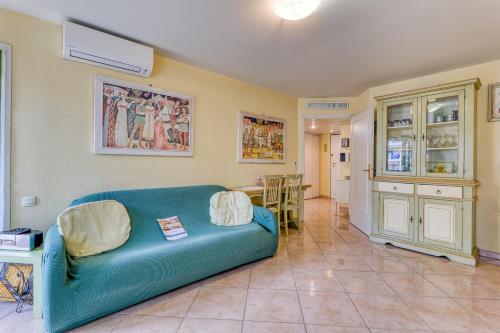 un salon avec un canapé bleu et une table dans l'établissement Garden View Daturas - Happy Rentals, à Menton