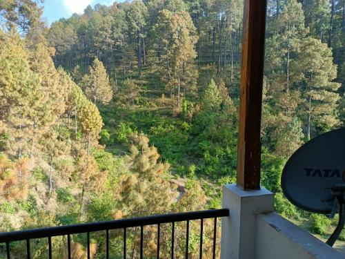 a room with a view of a forest at Nainital Cotteges in Rāmgarh