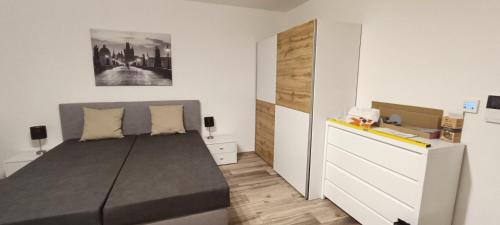 a bedroom with a bed and a white dresser at Aparthotel Praha in Prague