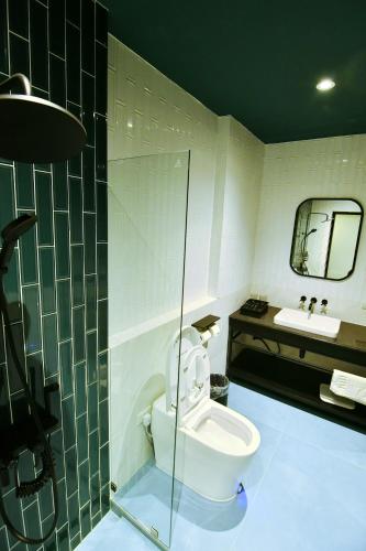 a bathroom with a toilet and a sink at เลอค่าเชียงแสน Le Quar Cafe BistroBed & Breakfast in Golden Triangle