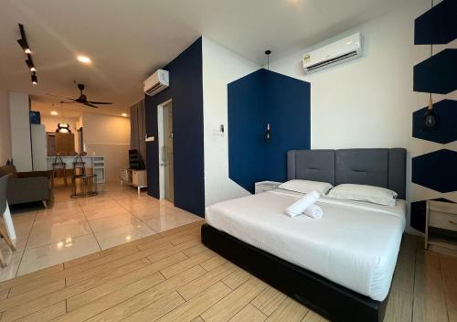 a bedroom with a white bed and a blue wall at ITCC Manhattan by IGVC in Penampang