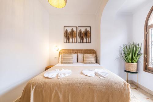 a bedroom with a bed with white bows on it at Sunrise Campello - Azahar Suite in El Campello