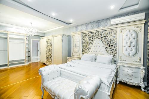 Un dormitorio con una gran cama blanca y un sofá. en Luxury AMOR Sea View Apartment 33, en Baku