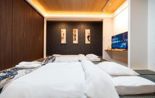 a bedroom with a large bed with white pillows at ohayo両国 in Tokyo