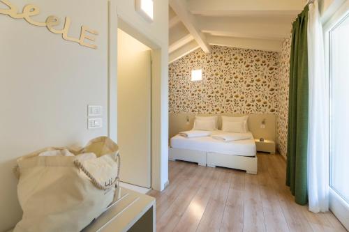 a small bedroom with a bed and a window at Hi Hotels Torbole - Heated Outdoor Pool & Spa in Nago-Torbole