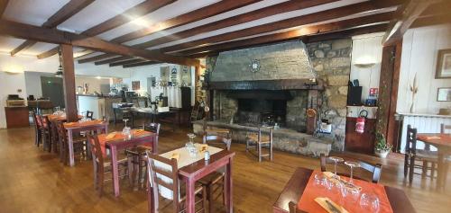 un restaurant avec des tables et des chaises et une cheminée dans l'établissement Hotel de la plage, à La Salvetat-sur-Agout