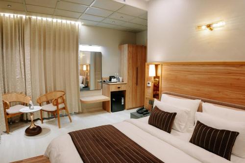 Una habitación de hotel con una cama, una mesa y una silla. en Villasita Resort, en Kankhal