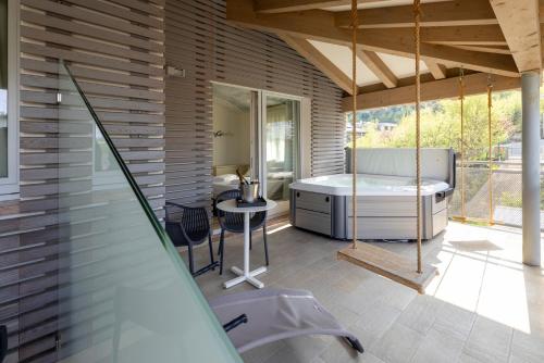 a bathroom with a tub and a table and a bath tub at Hi Hotels Torbole - Heated Outdoor Pool & Spa in Nago-Torbole
