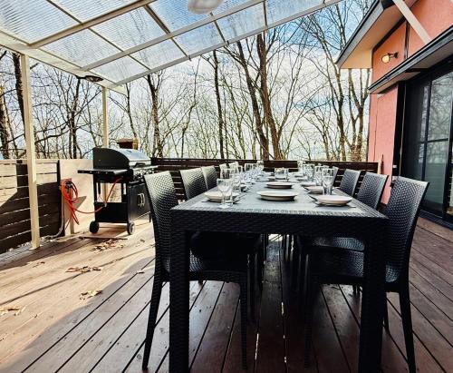 a table on a deck with chairs and a piano at TigerHouse in Nasu
