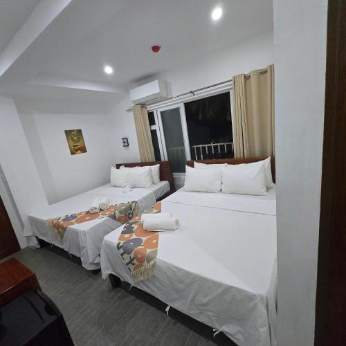 a bedroom with two beds and a window at Sunvilla beachfront hotel in Boracay