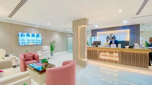 a lobby with a reception desk and pink chairs at Diafat AlSaadah Serviced Apartments- Qurtopa 2 in Riyadh