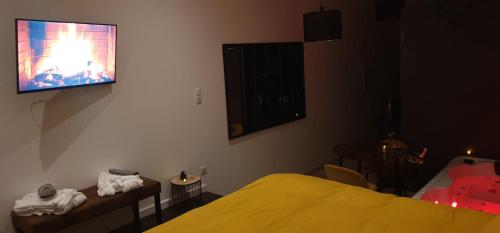 - une chambre avec un lit jaune et une télévision murale dans l'établissement Douce nuit, à Clapiers
