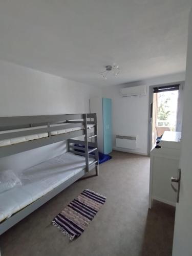 une chambre avec deux lits superposés et une fenêtre dans l'établissement Le fidgi - T3 6 personnes Parking privé Clim Terrasse proche plages, à Cagnes-sur-Mer
