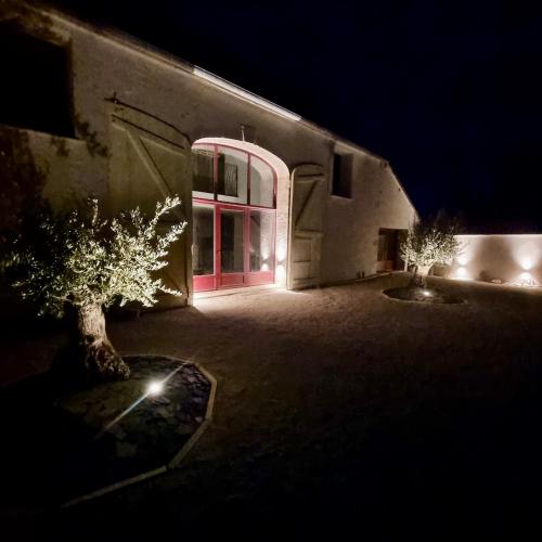 un bâtiment avec une porte rouge la nuit dans l'établissement Le Grand Gîte des Moyens-Ducs, à Josnes