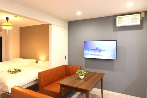 a room with a tv and a bed and a table at Shin Osaka Grand Heights SG31 in Osaka