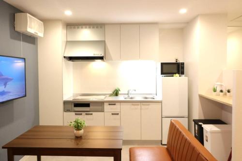 a kitchen with a table and a sink and a refrigerator at Shin Osaka Grand Heights SG31 in Osaka