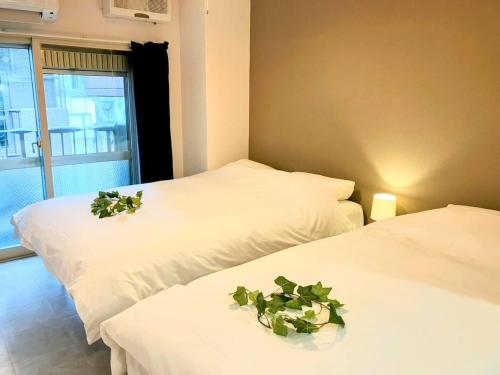 two beds with plants on them in a room at Shin Osaka Grand Heights SG31 in Osaka