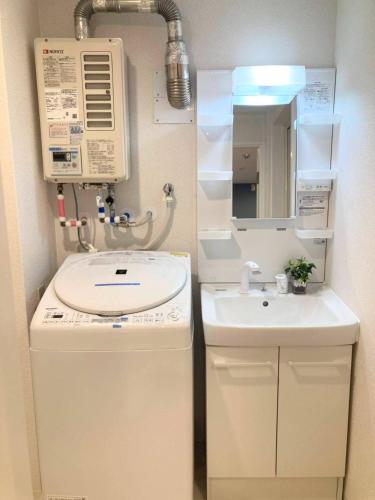 a small bathroom with a sink and a mirror at Shin Osaka Grand Heights SG31 in Osaka