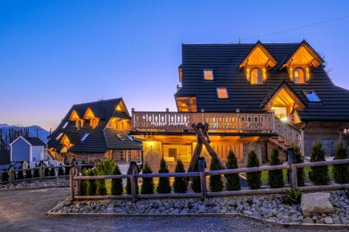 a large wooden house with a gambrel roof at Odkryj-Zakopane Tatra View Houses & SPA in Kościelisko
