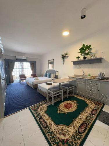 a kitchen and living room with a bed and a table at Rainbow Paradise Resort by Achlys Collection in Tanjung Bungah