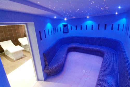 a swimming pool in a room with blue lights at Parklands Hotel & Country Club in Newton Mearns